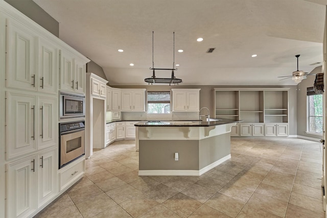 145 W Shore Dr, Montgomery, TX 77356 - kitchen featuring stainless steel appliances, recessed lighting, light tile patterned flooring, a center island with sink, and dark countertops