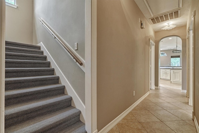 145 W Shore Dr, Montgomery, TX 77356 - stairs featuring tile patterned flooring, arched walkways, attic access, and baseboards