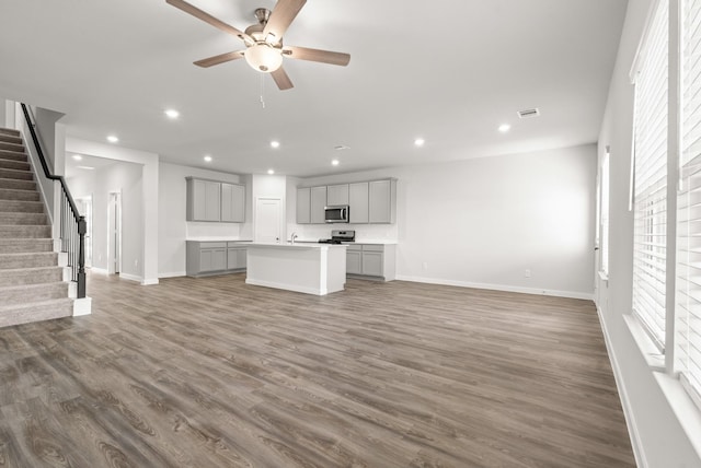 5803 Grantgrala Dr, Katy, TX 77493 - unfurnished living room with baseboards, plenty of natural light, stairway, recessed lighting, and wood finished floors