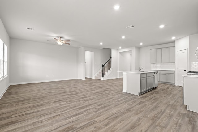 5803 Grantgrala Dr, Katy, TX 77493 - kitchen with gray cabinets, ceiling fan, open floor plan, recessed lighting, and a center island with sink