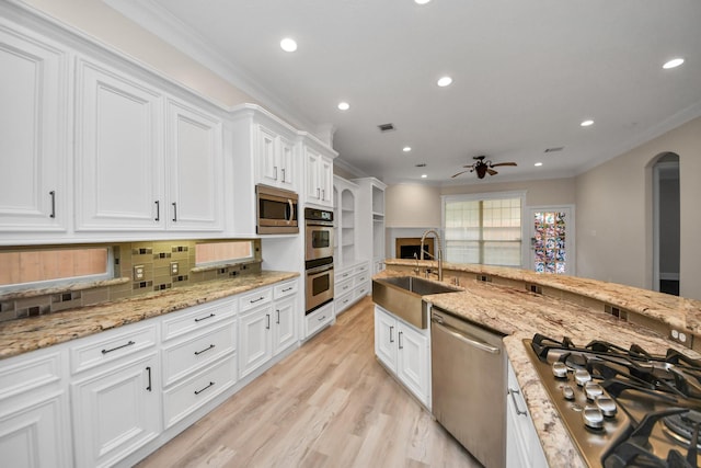 13523 Broadmeadow Ln, Houston, TX 77077 - kitchen with appliances with stainless steel finishes, a sink, arched walkways, a ceiling fan, and white cabinets
