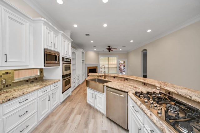 13523 Broadmeadow Ln, Houston, TX 77077 - kitchen featuring stainless steel appliances, a sink, ceiling fan, white cabinetry, and crown molding