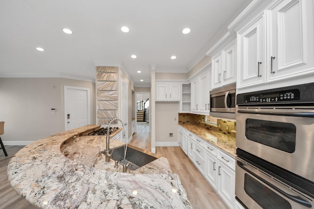 13523 Broadmeadow Ln, Houston, TX 77077 - kitchen featuring stainless steel appliances, light wood-style floors, baseboards, white cabinets, and recessed lighting