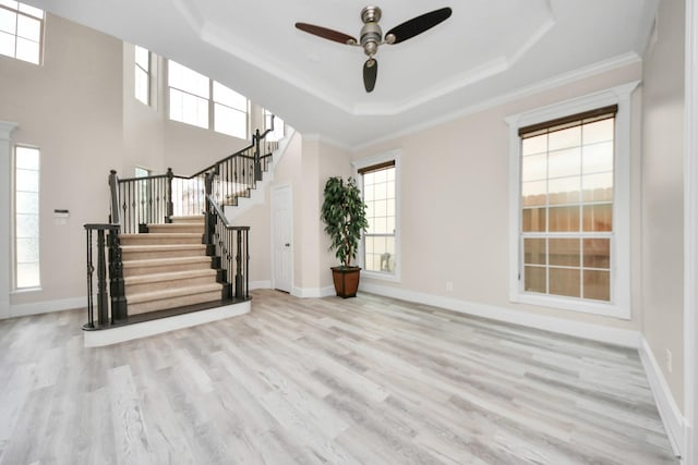 13523 Broadmeadow Ln, Houston, TX 77077 - unfurnished living room featuring a tray ceiling, stairway, wood finished floors, ceiling fan, and crown molding