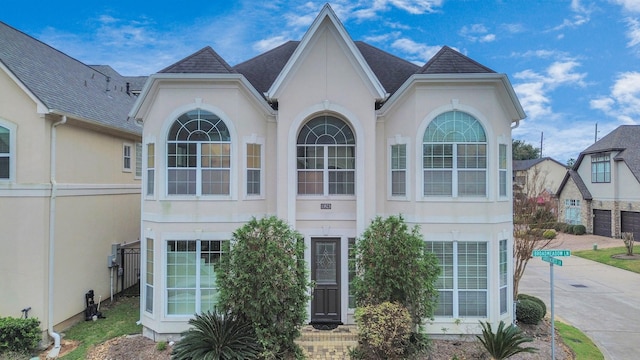 13523 Broadmeadow Ln, Houston, TX 77077 - view of front of house featuring stucco siding, roof with shingles, and concrete driveway