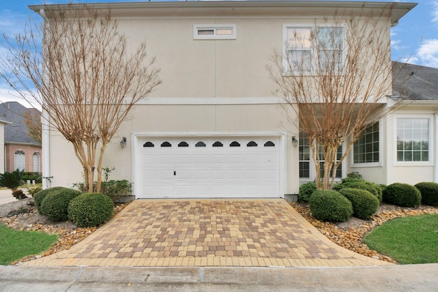 13523 Broadmeadow Ln, Houston, TX 77077 - view of front facade featuring decorative driveway, stucco siding, and an attached garage