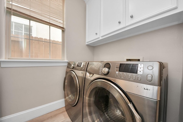 13523 Broadmeadow Ln, Houston, TX 77077 - laundry area featuring separate washer and dryer, cabinet space, baseboards, and light wood-style floors