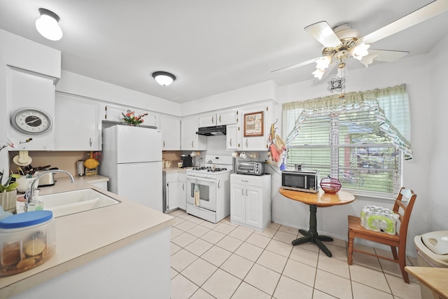 836 Sycamore St, Lake Jackson, TX 77566 - kitchen with white appliances, under cabinet range hood, light tile patterned floors, light countertops, and white cabinets