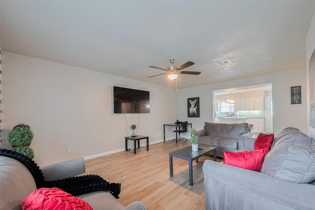 5825 Village Forest Ct, Houston, TX 77092 - living room featuring light wood-style flooring, ceiling fan, a textured ceiling, and baseboards
