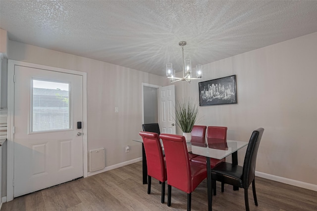 5825 Village Forest Ct, Houston, TX 77092 - dining room featuring a chandelier, wood finished floors, a textured ceiling, and baseboards