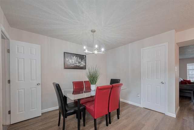 5825 Village Forest Ct, Houston, TX 77092 - dining space with a chandelier, wood finished floors, a textured ceiling, and baseboards