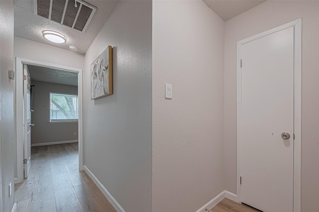 5825 Village Forest Ct, Houston, TX 77092 - hall with light wood-style flooring, baseboards, and a textured ceiling