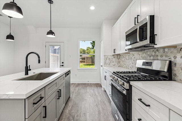 990-992 Marjorie St, Houston, TX 77088 - kitchen with appliances with stainless steel finishes, a sink, light wood-type flooring, backsplash, and recessed lighting