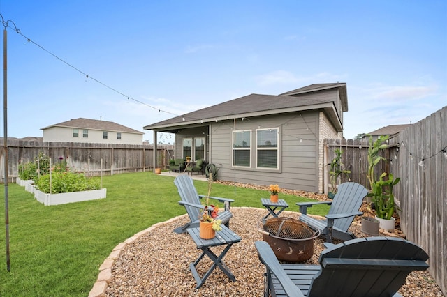 rear view of property with an outdoor fire pit, a garden, and a patio area