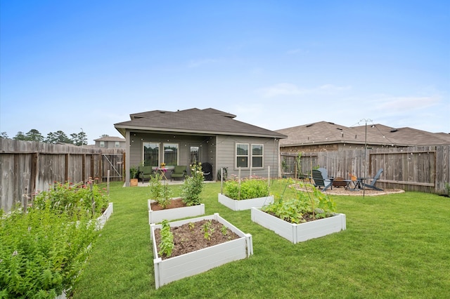 rear view of property featuring a garden, a fire pit, and a shingled roof