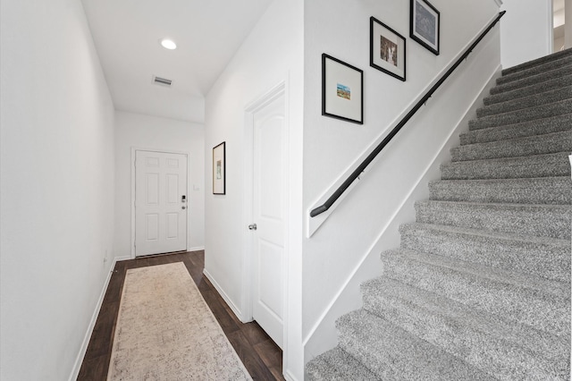 stairs featuring wood finished floors, baseboards, and recessed lighting