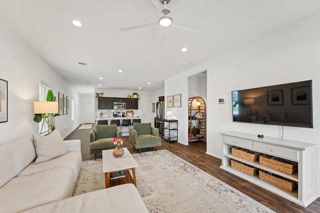 living room featuring recessed lighting, dark wood-style flooring, ceiling fan, baseboards, and ornate columns