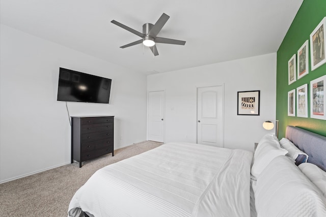 bedroom with light colored carpet, ceiling fan, and baseboards