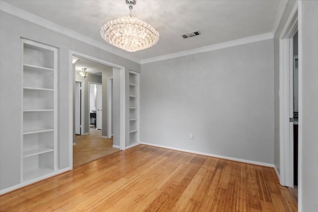 10203 Huntington Dale Dr, Houston, TX 77099 - empty room featuring a chandelier, built in shelves, ornamental molding, light wood-type flooring, and baseboards