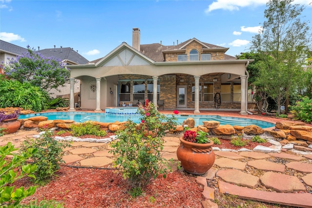 6318 Goodlowe Park, Sugar Land, TX 77479 - back of house with a chimney, a pool with connected hot tub, a patio, and stucco siding