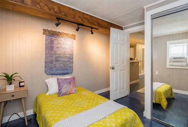 16535 Jamaica Inn Rd, Jamaica Beach, TX 77554 - bedroom with rail lighting, baseboards, and wooden walls