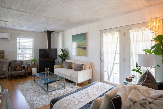 16535 Jamaica Inn Rd, Jamaica Beach, TX 77554 - living area with a wall mounted AC, a wood stove, wooden ceiling, hardwood / wood-style flooring, and a chandelier