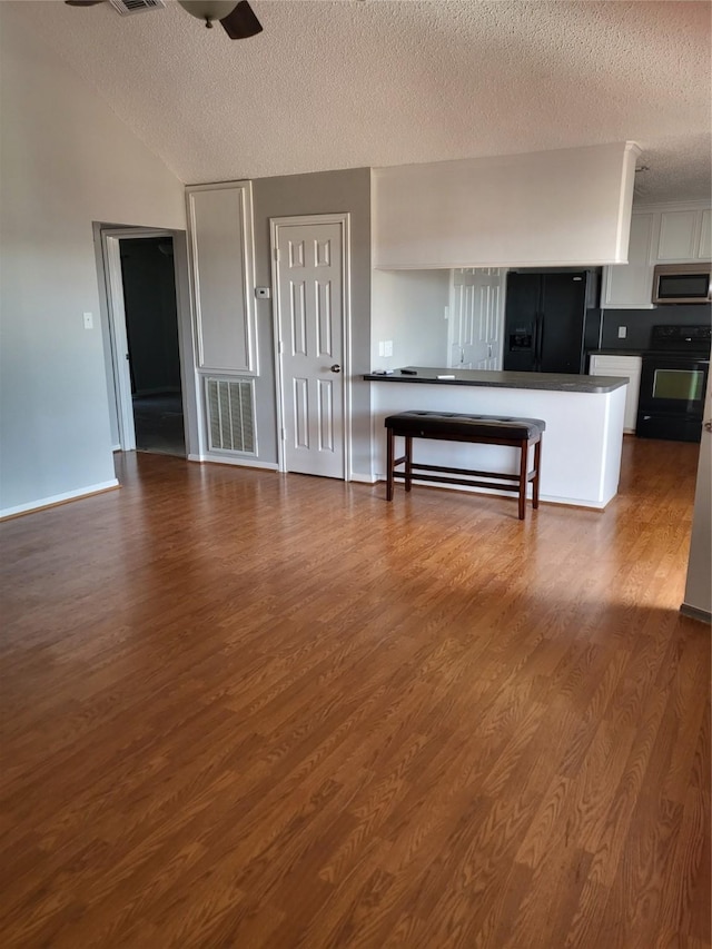 106 Driftwood Rd, Freeport, TX 77541 - living area featuring a textured ceiling, dark wood-type flooring, ceiling fan, and vaulted ceiling