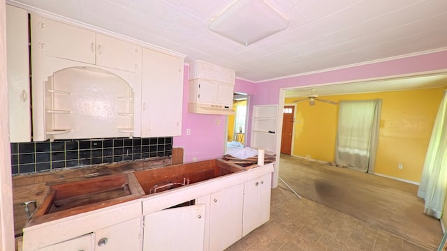kitchen featuring white cabinets, ceiling fan, and crown molding