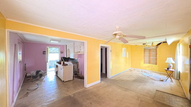 unfurnished living room featuring a ceiling fan, baseboards, and ornamental molding