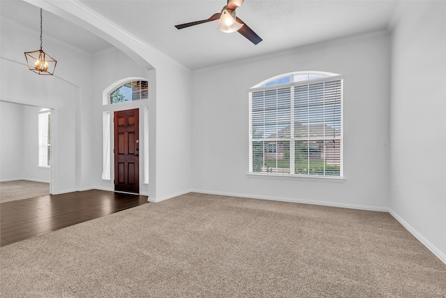 3031 Clover Trace Dr, Spring, TX 77386 - entrance foyer with dark colored carpet, ornamental molding, a chandelier, a ceiling fan, and baseboards