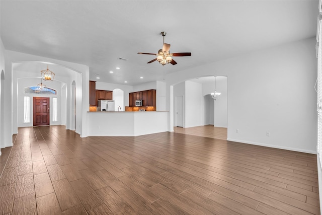 3031 Clover Trace Dr, Spring, TX 77386 - unfurnished living room with a chandelier, ceiling fan, arched walkways, wood finished floors, and recessed lighting