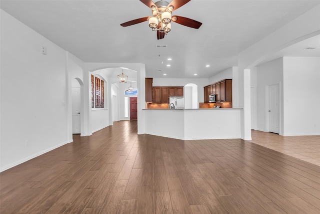 3031 Clover Trace Dr, Spring, TX 77386 - unfurnished living room featuring ceiling fan, dark wood-style flooring, arched walkways, recessed lighting, and baseboards