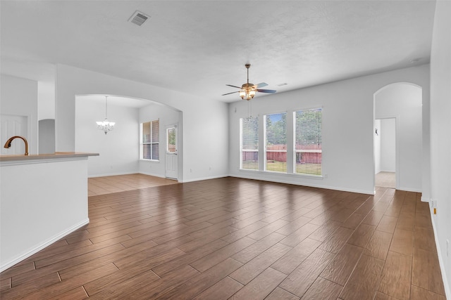 3031 Clover Trace Dr, Spring, TX 77386 - unfurnished living room featuring a ceiling fan, arched walkways, wood finished floors, and baseboards