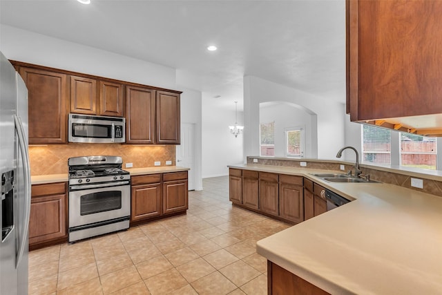 3031 Clover Trace Dr, Spring, TX 77386 - kitchen with appliances with stainless steel finishes, a sink, backsplash, arched walkways, and plenty of natural light