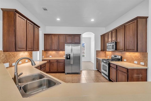 3031 Clover Trace Dr, Spring, TX 77386 - kitchen with stainless steel appliances, a sink, arched walkways, tasteful backsplash, and recessed lighting