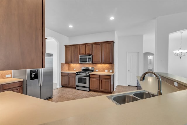 3031 Clover Trace Dr, Spring, TX 77386 - kitchen with appliances with stainless steel finishes, arched walkways, a sink, tasteful backsplash, and recessed lighting