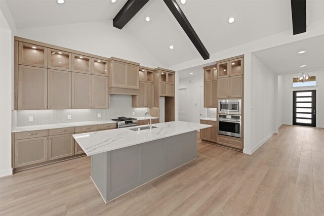 16163 Rustling Woods Rd, Conroe, TX 77302 - kitchen with appliances with stainless steel finishes, a sink, beam ceiling, decorative backsplash, and light wood-type flooring