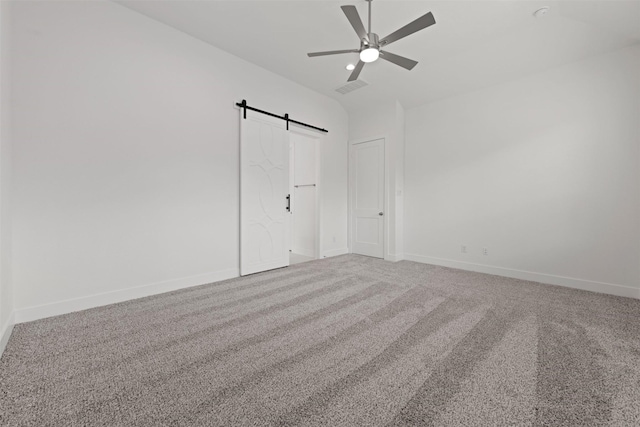 16163 Rustling Woods Rd, Conroe, TX 77302 - empty room with ceiling fan, a barn door, carpet flooring, baseboards, and vaulted ceiling