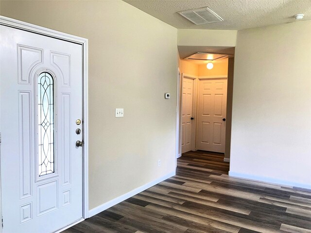 10479 Royal Tricia Dr, Conroe, TX 77303 - foyer entrance featuring dark wood-style floors, baseboards, and a textured ceiling