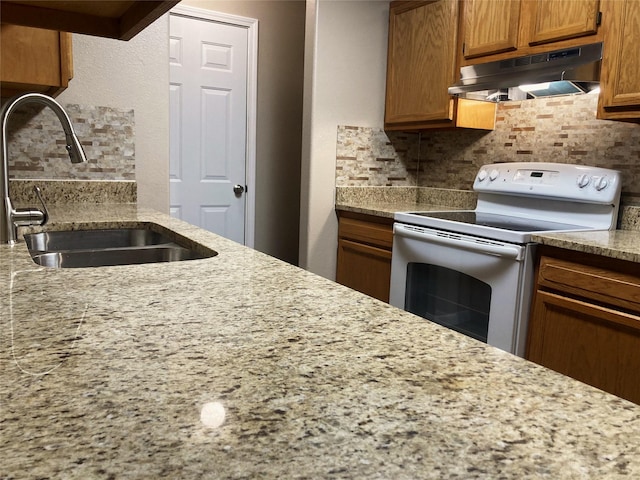10479 Royal Tricia Dr, Conroe, TX 77303 - kitchen featuring white range with electric stovetop, under cabinet range hood, a sink, and tasteful backsplash
