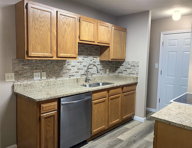 10479 Royal Tricia Dr, Conroe, TX 77303 - kitchen with stainless steel dishwasher, a sink, light wood-type flooring, decorative backsplash, and baseboards