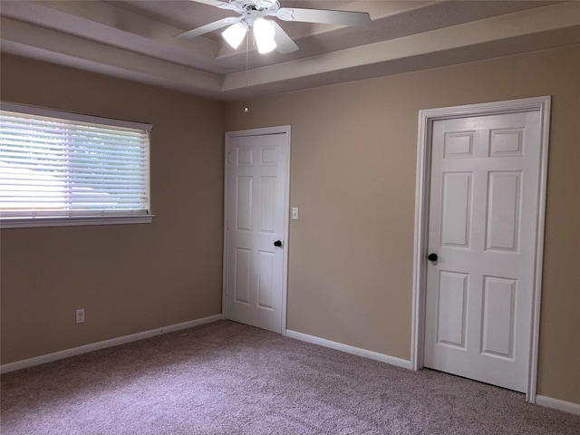 10479 Royal Tricia Dr, Conroe, TX 77303 - unfurnished bedroom with light carpet, baseboards, a tray ceiling, and ceiling fan