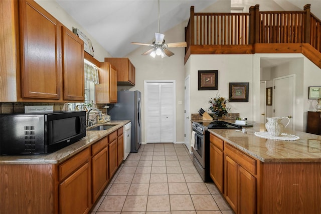 999 Salem Rd, Brenham, TX 77833 - kitchen with stainless steel range with electric cooktop, black microwave, a sink, ceiling fan, and light stone counters