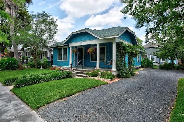 1119 E 7th 1/2 St, Houston, TX 77009 - bungalow-style house with covered porch, a front lawn, roof with shingles, and driveway