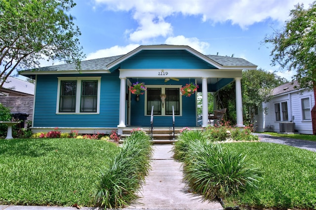 1119 E 7th 1/2 St, Houston, TX 77009 - bungalow-style home with covered porch, a front yard, central air condition unit, and roof with shingles