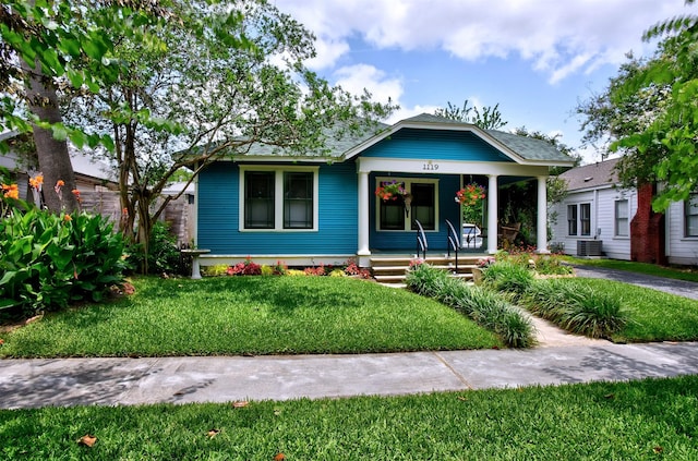 1119 E 7th 1/2 St, Houston, TX 77009 - bungalow-style house with a porch, a front yard, and central AC