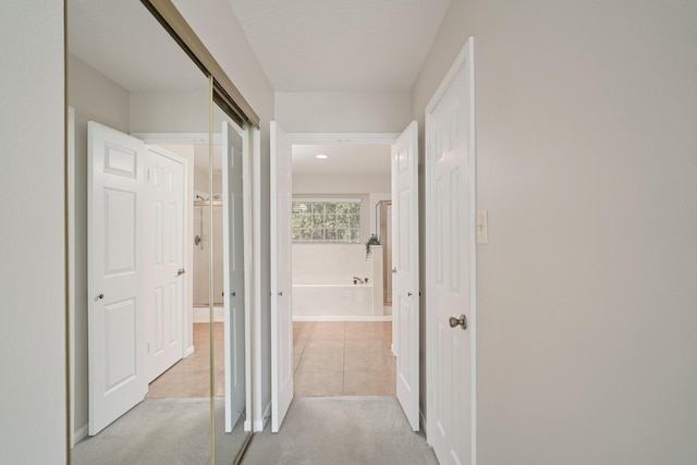 8602 Canyon Pine Dr, Spring, TX 77379 - hall with light tile patterned floors, light carpet, and baseboards