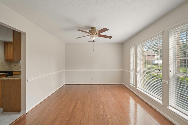 8602 Canyon Pine Dr, Spring, TX 77379 - spare room with light wood-style flooring, a ceiling fan, and baseboards
