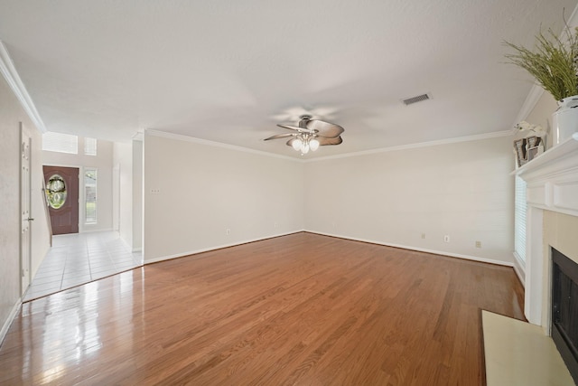 8602 Canyon Pine Dr, Spring, TX 77379 - unfurnished living room featuring a ceiling fan, crown molding, a fireplace with flush hearth, wood finished floors, and baseboards