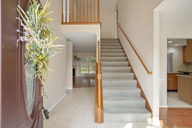 8602 Canyon Pine Dr, Spring, TX 77379 - stairs featuring tile patterned floors, a fireplace, and baseboards